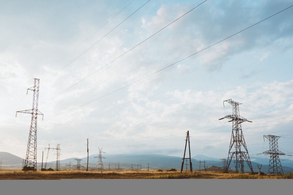 Wide angle shot of many electric posts on a dry landscape under a cloudy sky